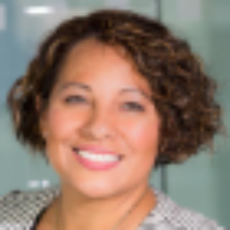 A lady with short curly hair in a business jacket